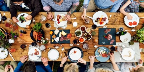 Group of people eating around a rustic dining table