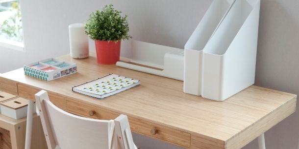 wooden office desk with white office chair and magazine boxes