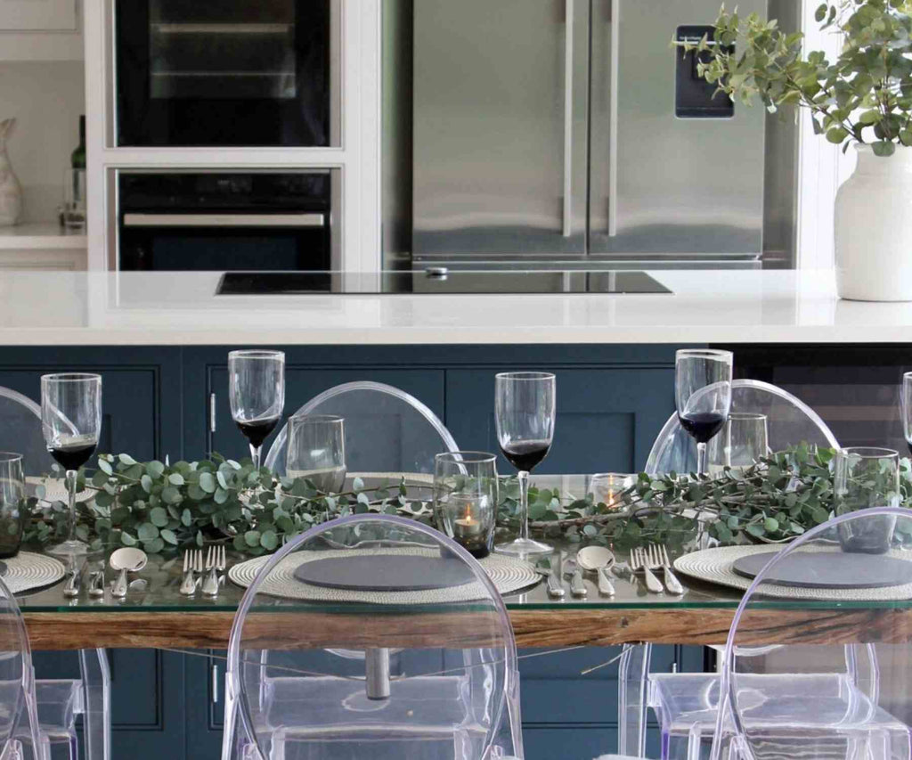 Green foliage in centre of a dinner table with clear plastic chairs