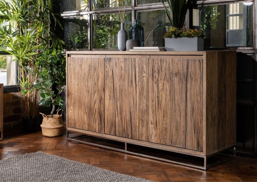 Reclaimed wood large sideboard against dark wall with green plants