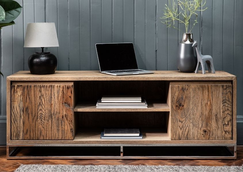 Reclaimed wood TV unit with two cupboards and middle shelf, with laptop and lamp on top