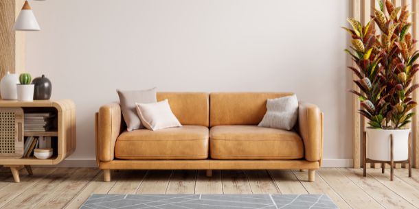 brown leather 2-seater sofa with large house plant and wooden side table