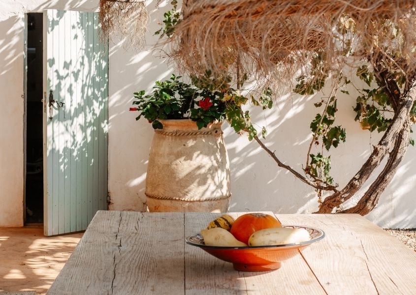 outdoor wooden dining table with straw hanging lamp shade