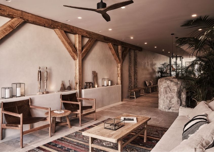 wooden armchairs and rustic coffee table in lobby area of the Habitat hotel, Mykonos
