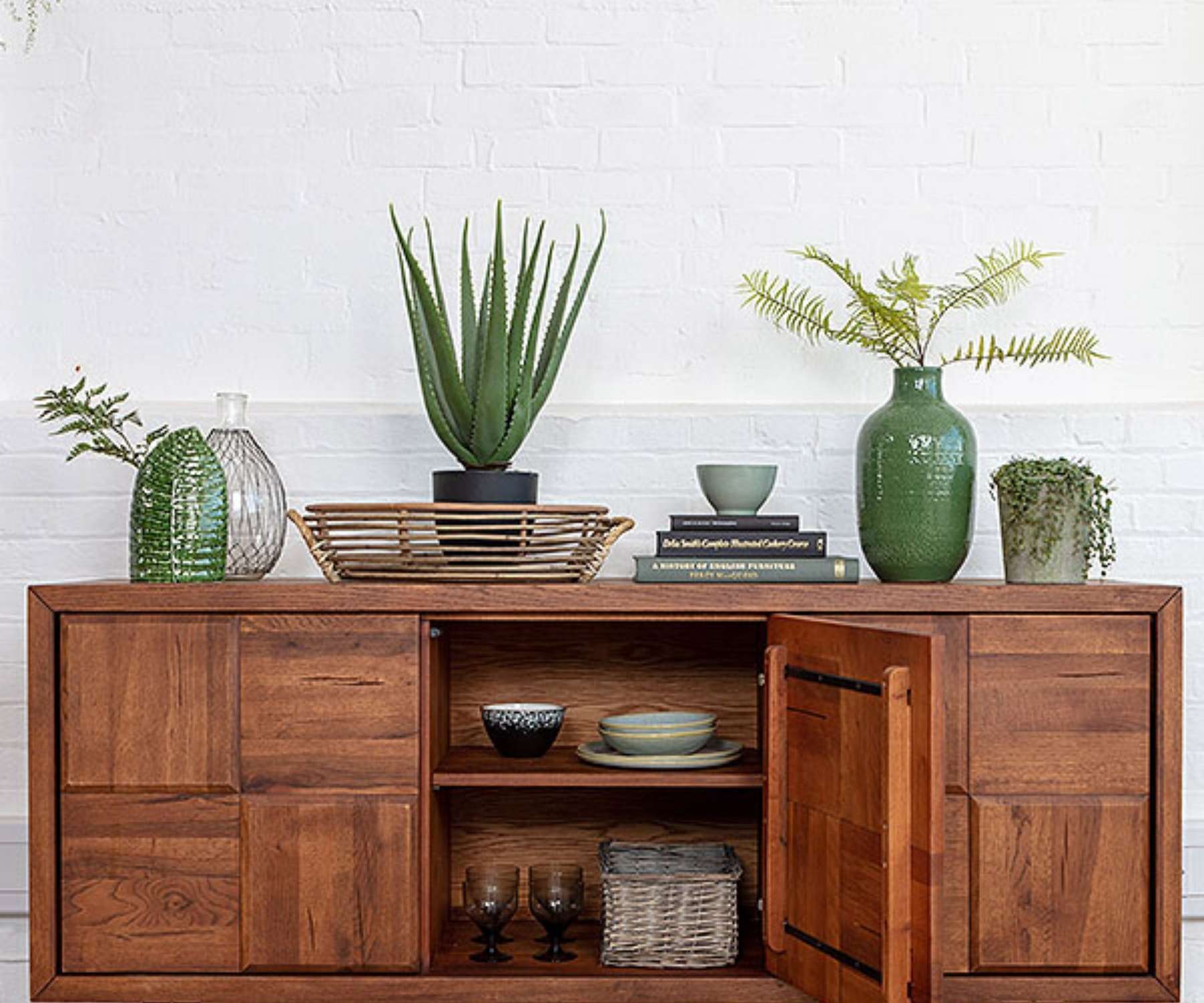 open oak dresser with plants and ornaments