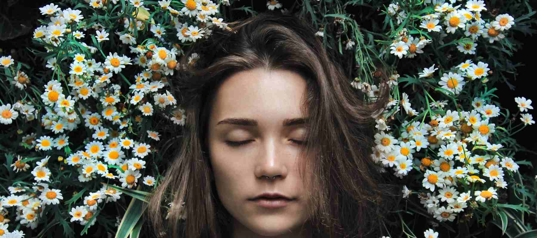 Girl asleep amongst daisy flowers