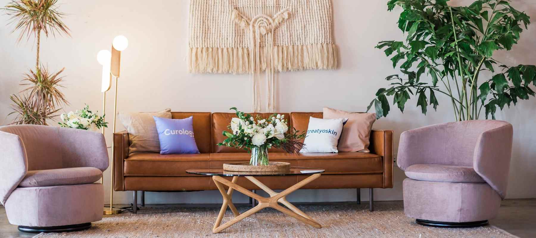 Brown leather sofa in living room with two small side chairs
