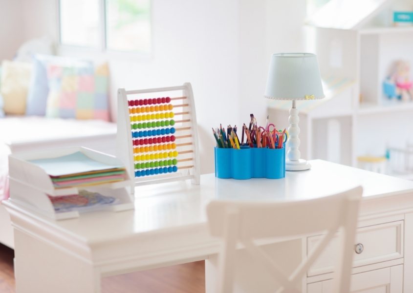 white wooden desk with blue pen pot