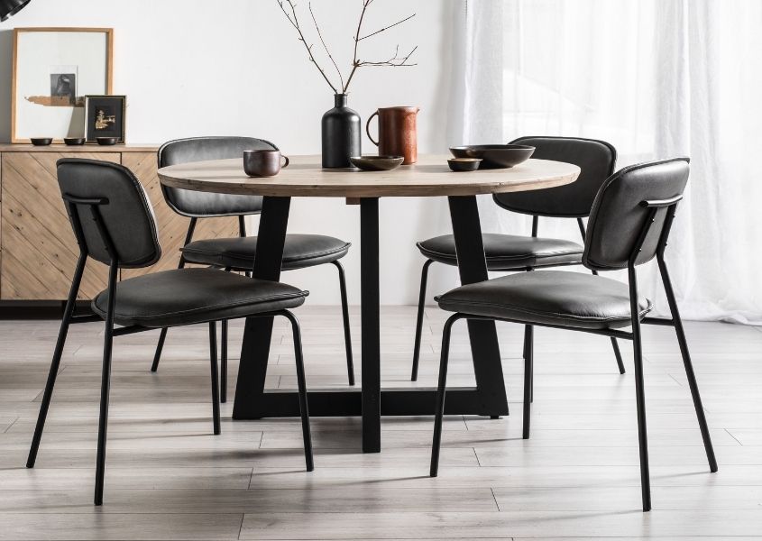 round reclaimed wood dining table with grey faux leather dining chairs