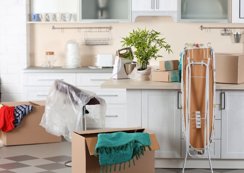 kitchen with moving boxes and iron board for tips to prepare for an easy house move blog
