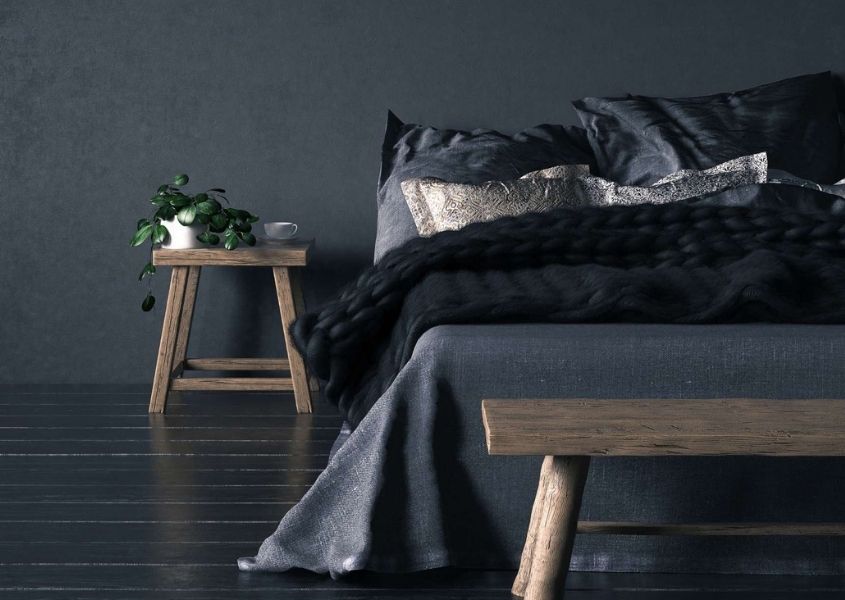 dark bedroom with rustic bedside table and wooden bench