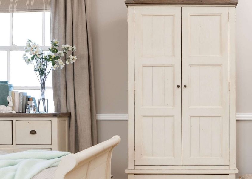 white wooden wardrobe and white painted bed