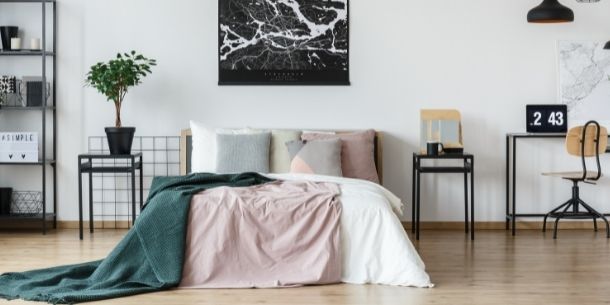 double bed frame with pin and green covers and industrial bedside tables