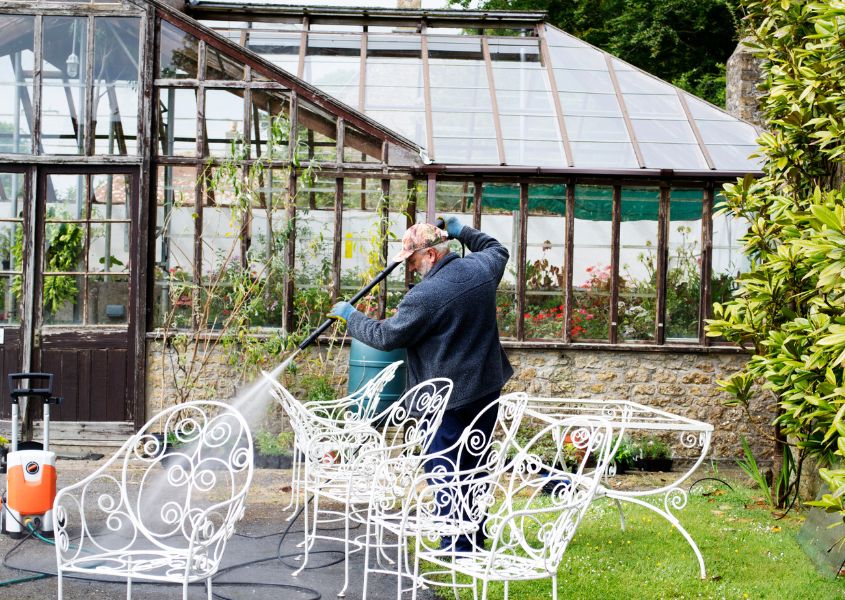 man cleaning metal outdoor furniture