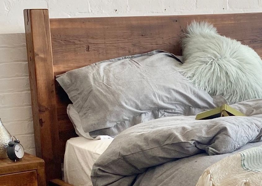 reclaimed wooden headboard with grey covers