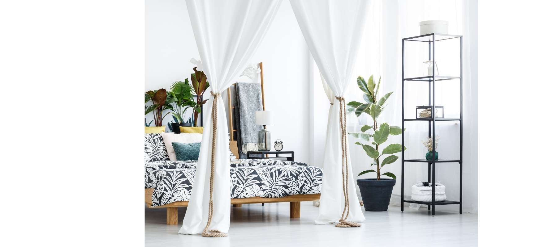 White four poster bed with green plants and industrial bookcase