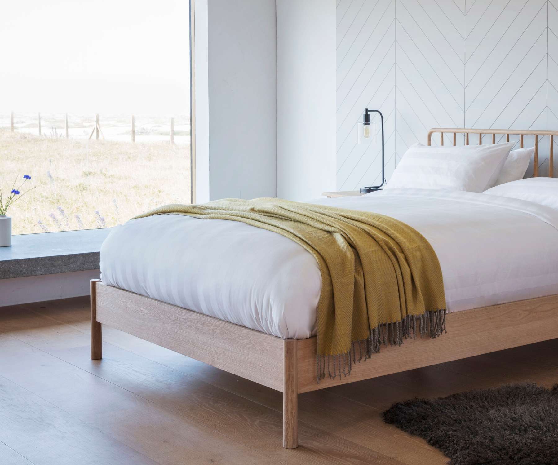 white bedding with mustard throw