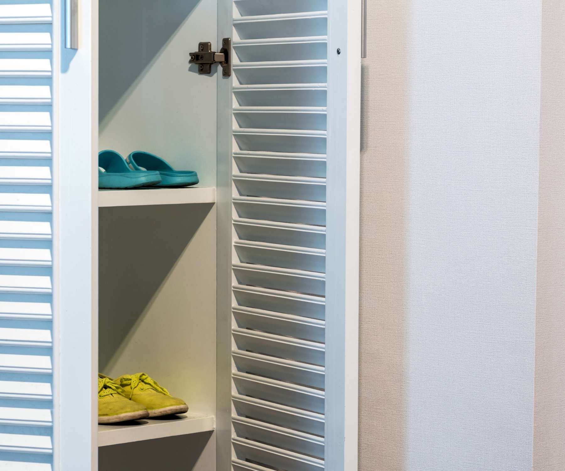 white wooden storage unit with louvered doors